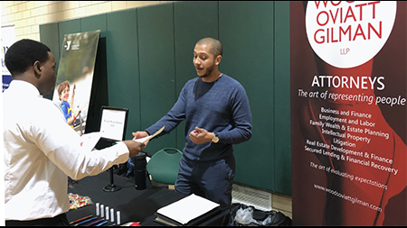 Student exchanging information with an employer at a career fair