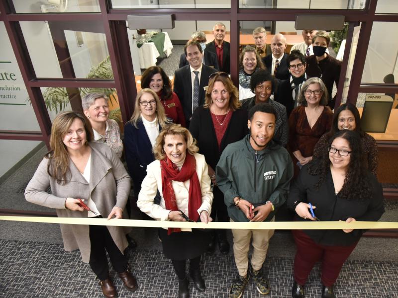Members of the college community cut a ribbon to symbolize the opening of the SUNY Oswego Institute for Equity, Diversity, Inclusion, and Transformative Practice in Penfield Library