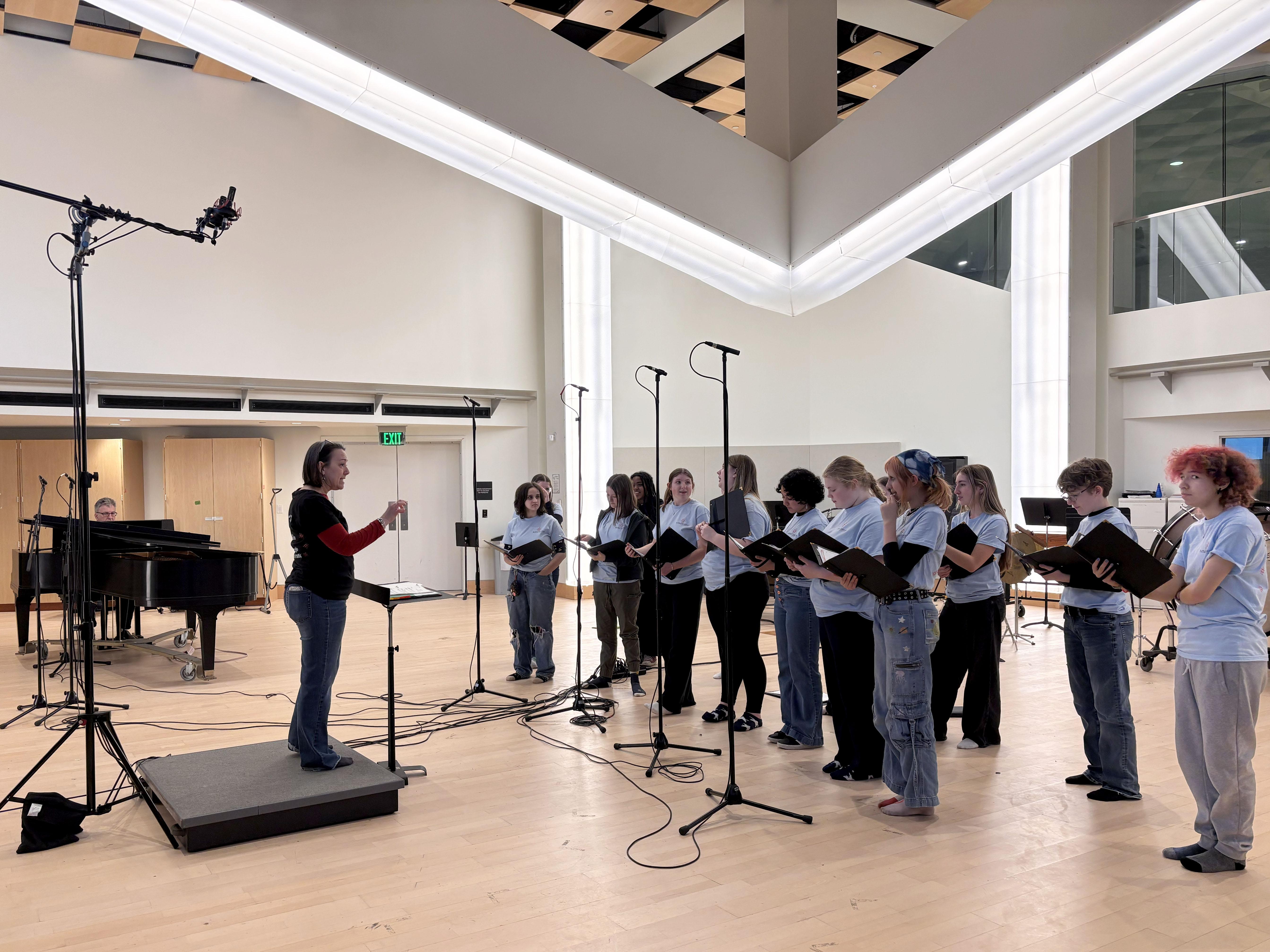 Kathleen Bassett, founder and artistic director of Buffalo Girlchoir, leads a collaborative session between the visiting choir and SUNY Oswego's State Singers in Tyler Hall