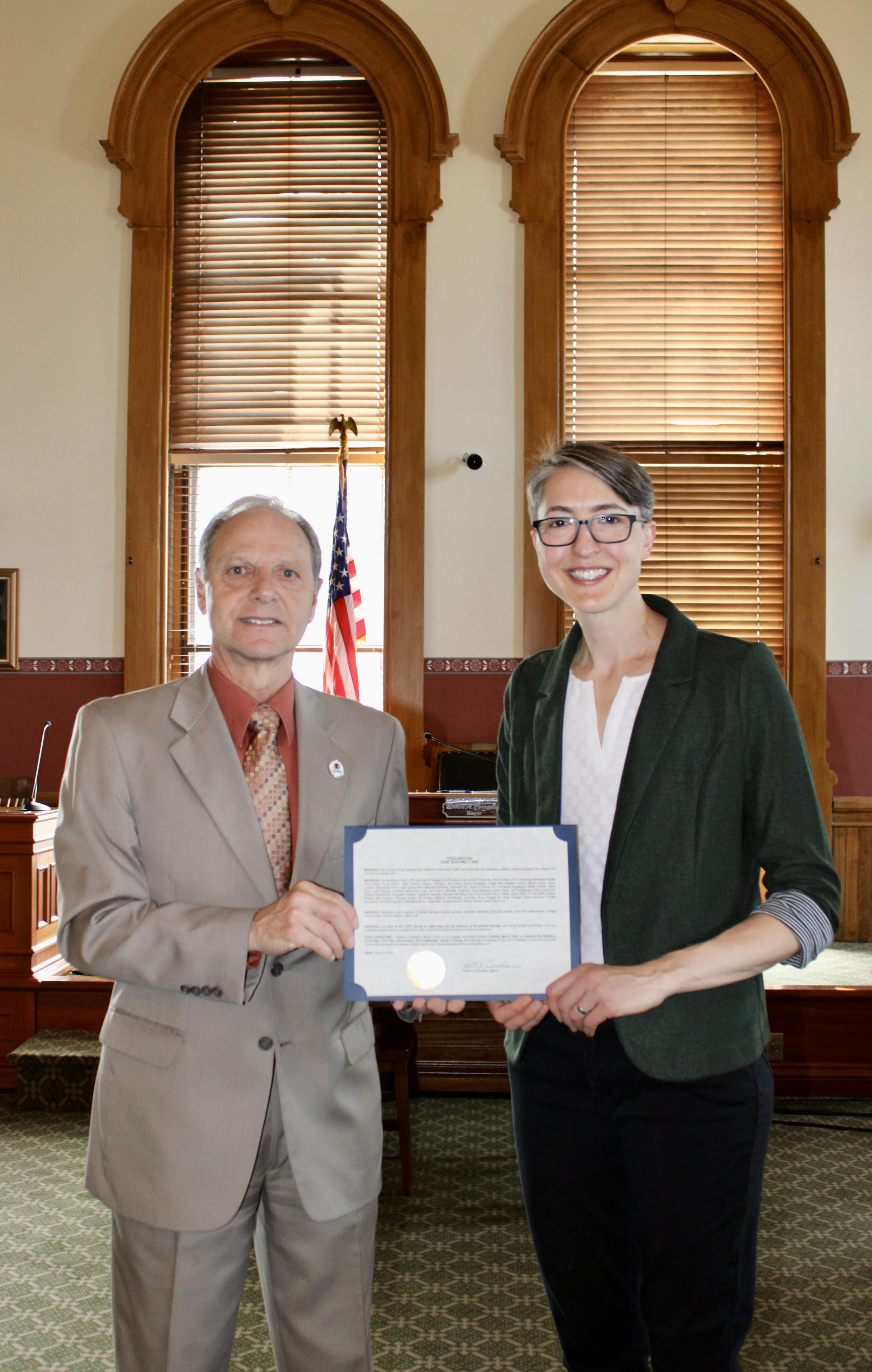 City of Oswego Mayor Robert Corradino shares a proclamation to honor the "One City. One Campus. One Community." photojournalism project with SUNY Oswego Assistant Vice President of Workforce Innovation and External Relations Kristi Eck 