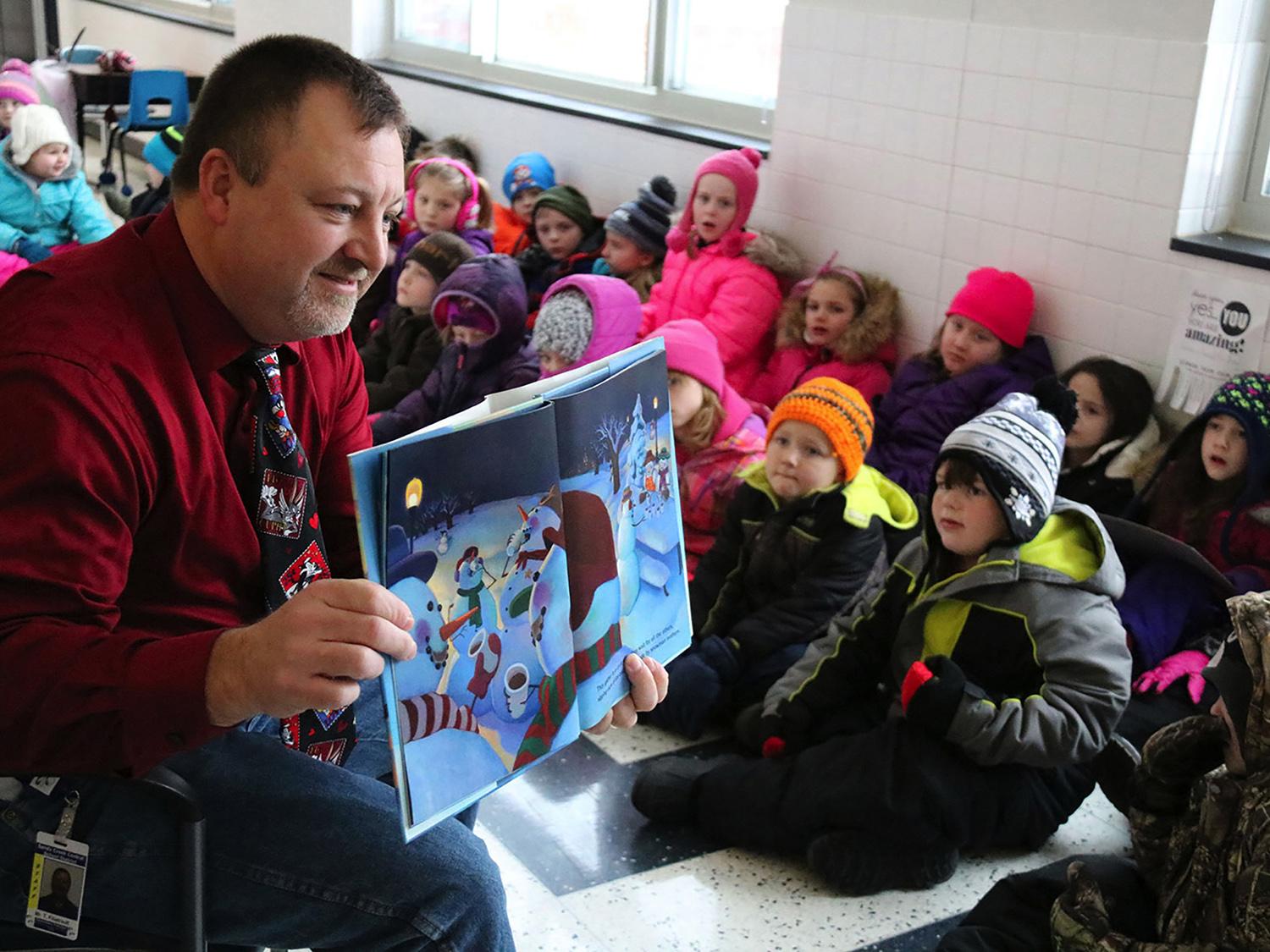 Sandy Creek Elementary School Principal Tim Filiatrault shares a book with young readers