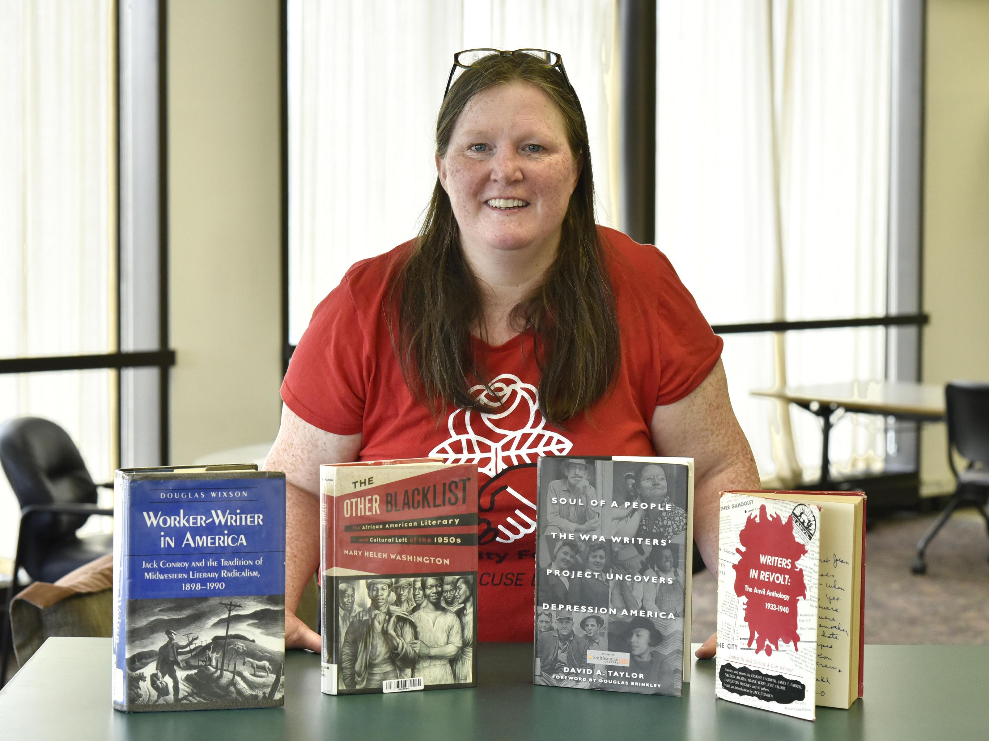 Maureen Curtin with books in Penfield Library