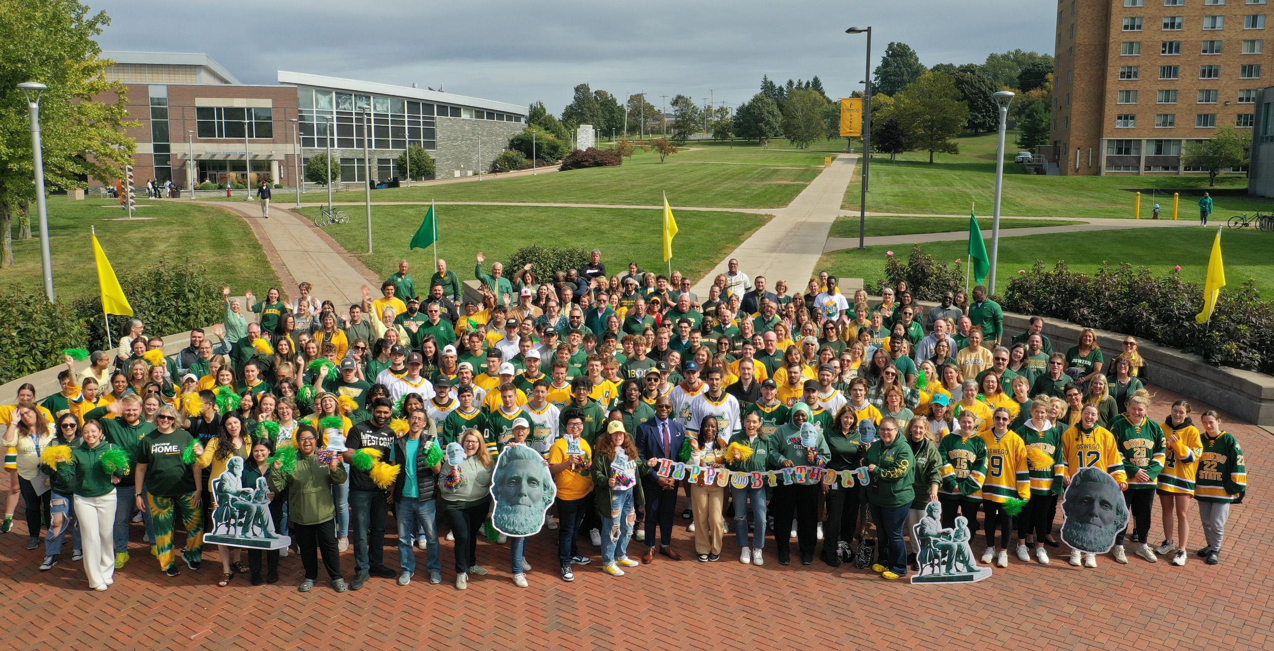 Members of the campus community wearing green and gold