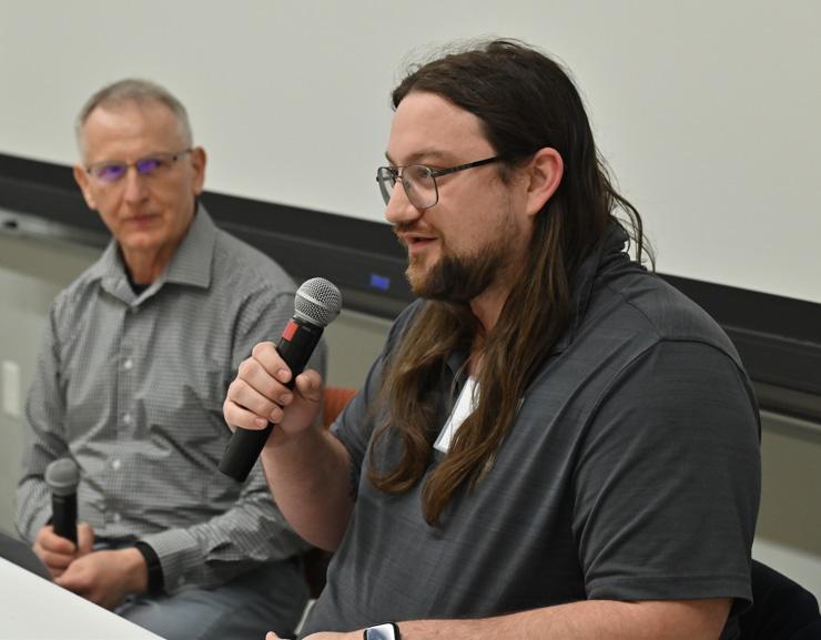 Kenny Roffo, a 2017 SUNY Oswego graduate whose accomplishments since included working on the InSight rover that landed on Mars for NASA, speaks to a full house as electrical and computer engineering faculty member Adrian Ieta looks on.