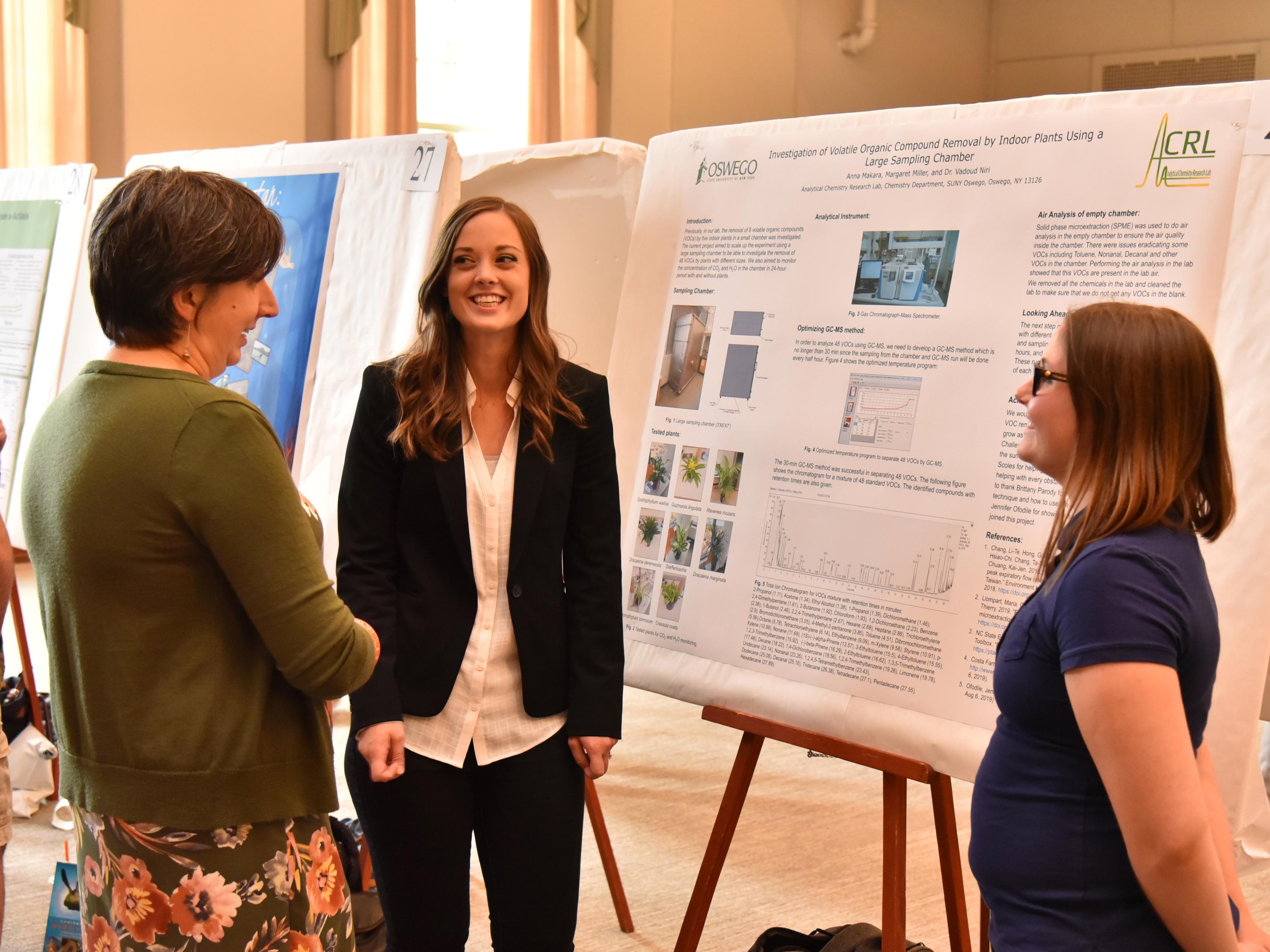Julia Koeppe speaks with students Anna Makara and Maggie Miller about their research in analytical chemistry