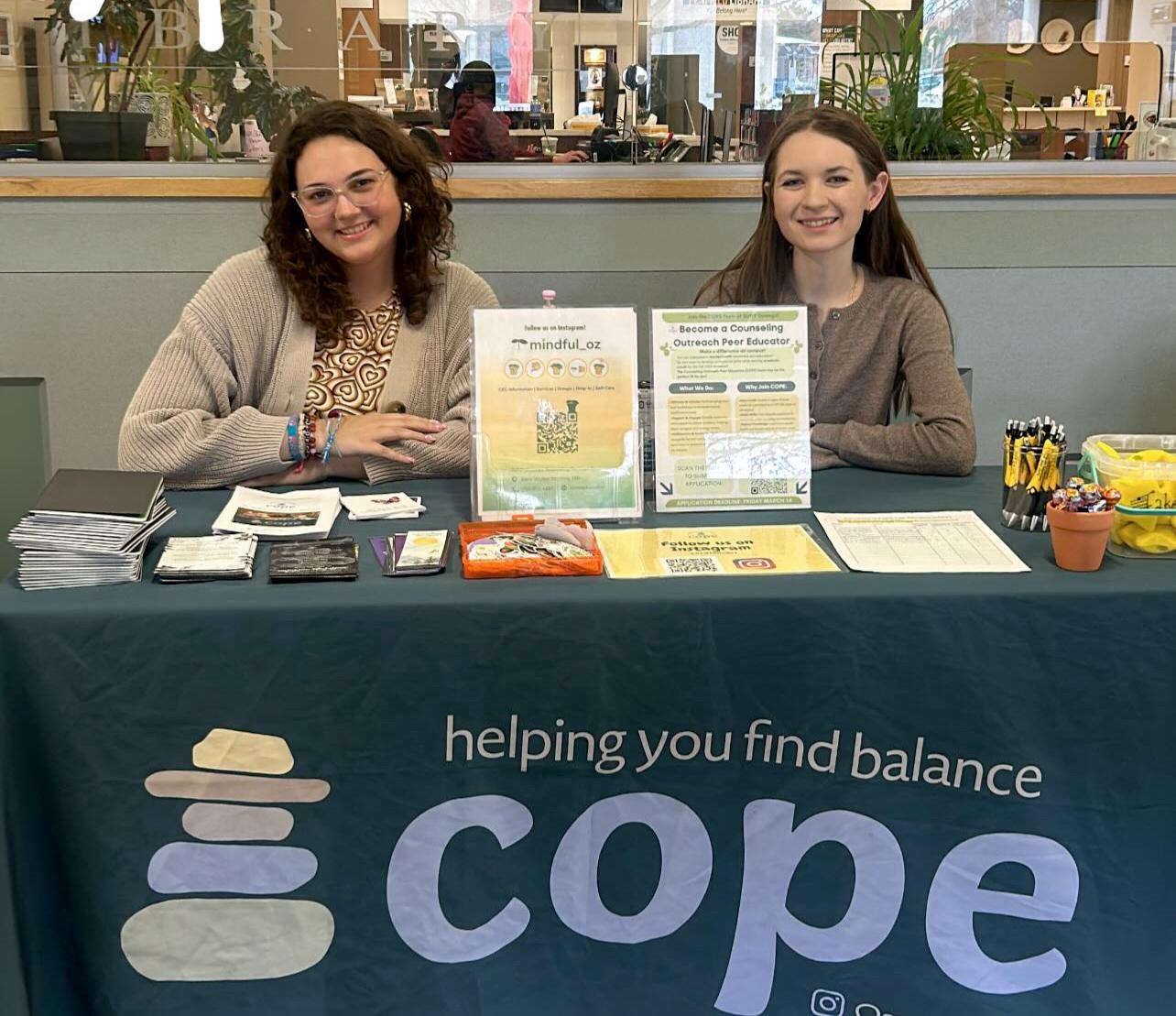 Patrycja Kulesza (right) and Madison Flood table for SUNY Oswego's Counseling Outreach Peer Educators