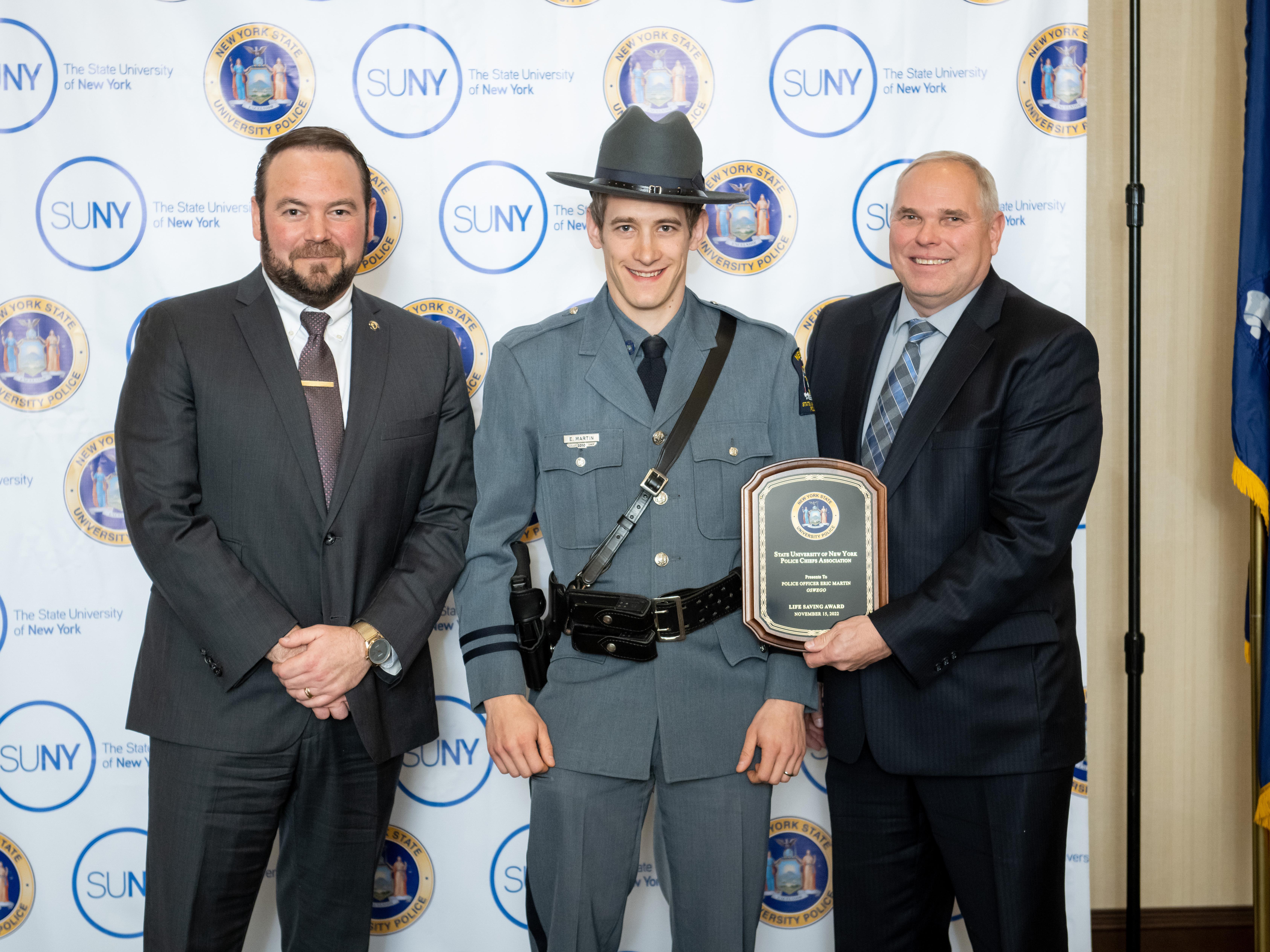 SUNY Oswego University Police Officer Eric Martin (center) earned honors during the 2022 University Police Awards; here he is congratulated by Chief Scott Swayze and Kevin Velzy, who retired as chief earlier this year