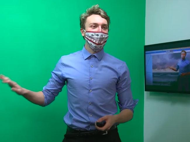 Daniel Maslowski gives a weather forecast in front of a green screen in the Shineman Center