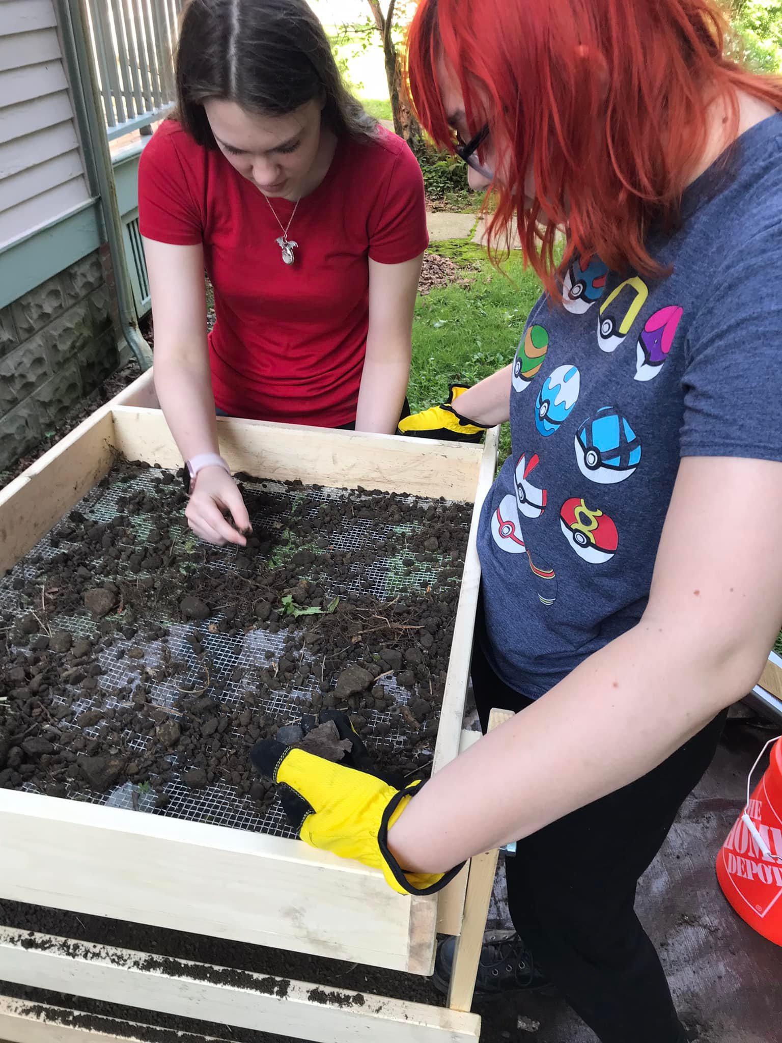 SUNY Oswego student archaeologists dig in while examining items they have unearthed at the local historic home and museum known as the Richardson-Bates House