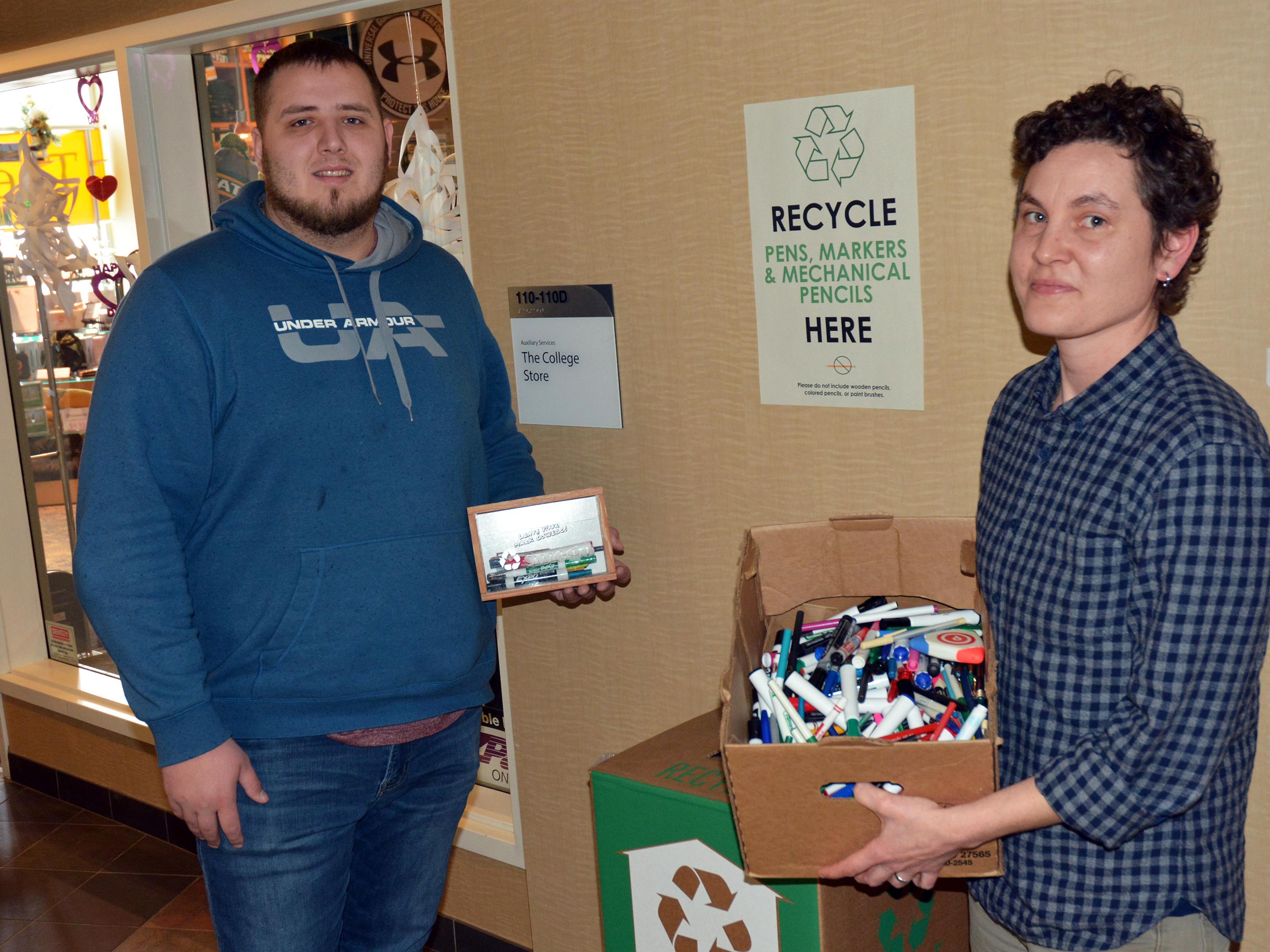 Kate Spector and student assistant Connor Haney prepare to feed used writing implements to a TerraCycle zero waste recycling box 