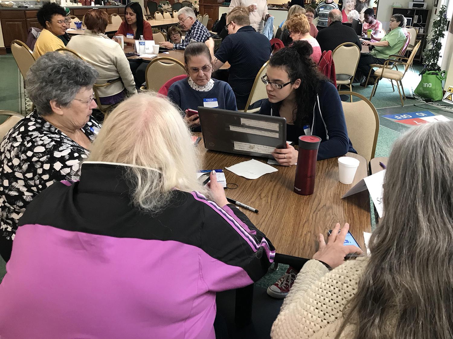 Students help senior citizens with technology questions