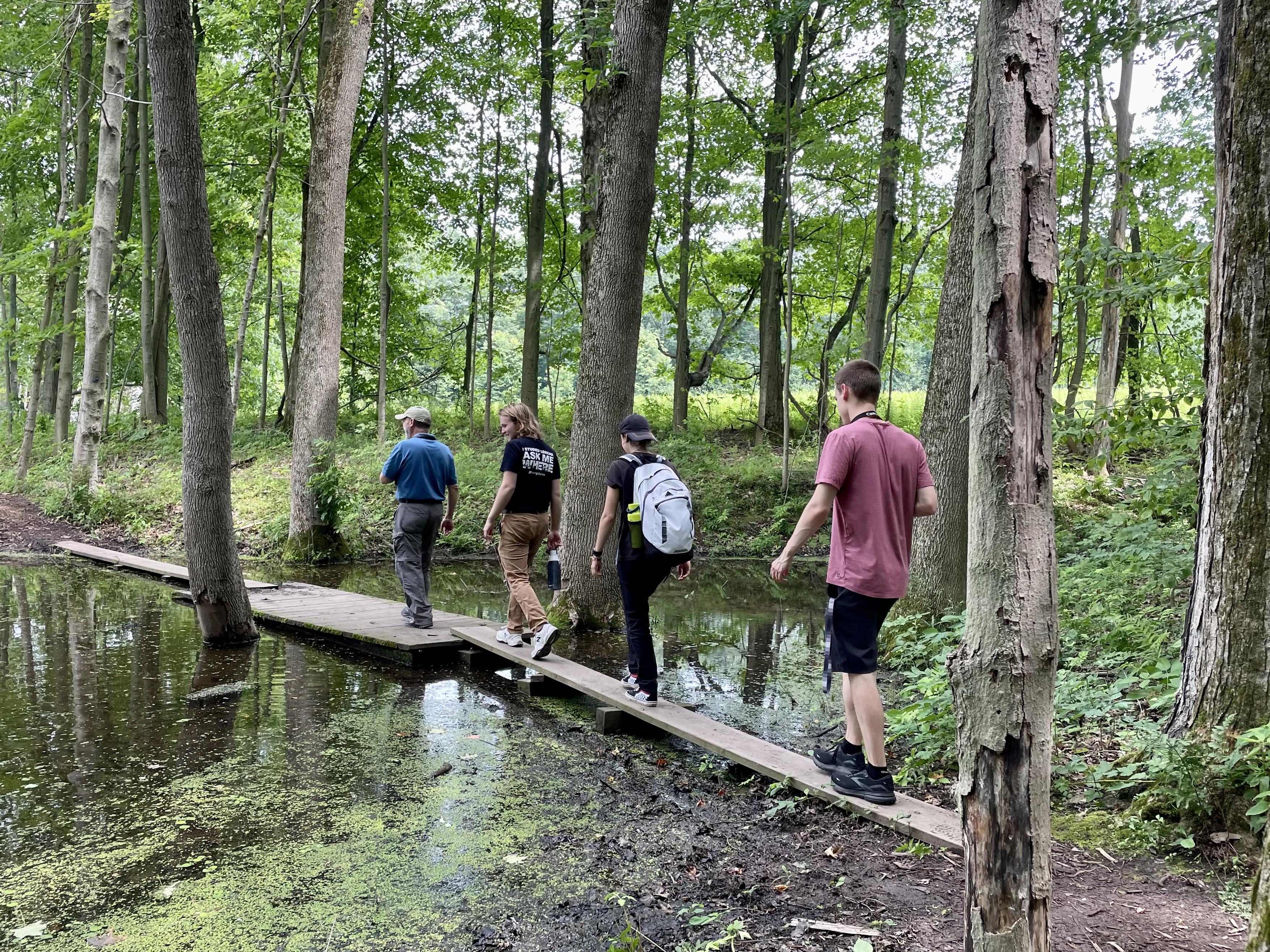 alking a trail are, from left, Jim D'Angelo, director of Sterling Nature Center, with student filmmakers Wells Liscomb and Lauren Smith (both seniors) and Ryan King (who graduated in 2023).