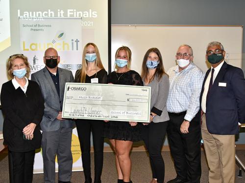 Student winners of the 2021 Launch It business competition pose with big check with faculty, dean of School of Business and competition judges.