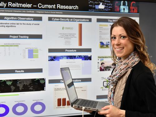Holly Reitmeier with cybersecurity research poster