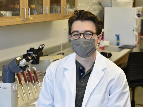 Christian DiBiase sits in a Shineman Center lab surrounded by research equipment