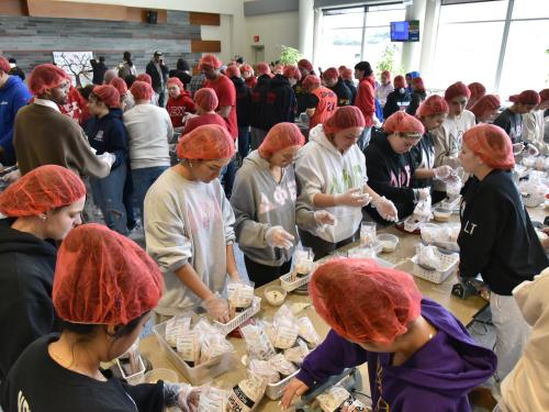 SUNY Oswego's MLK Day of Service, shown here with  students preparing food to help local agency Rise Against Hunger