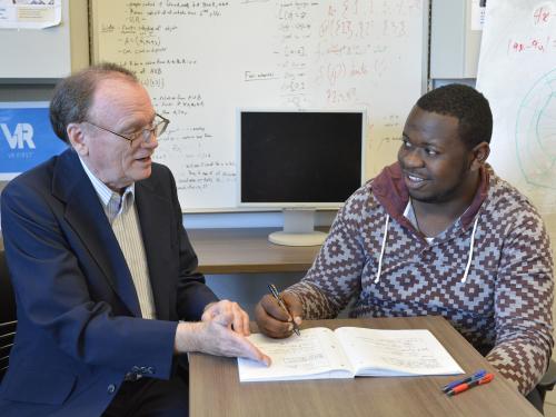 Faculty member David Vampola speaks with student Kingsley Ibezim