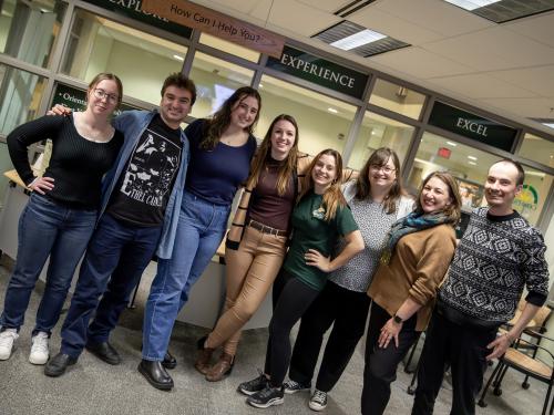 Staff and student members of the Experiential Learning office stand in front of the Compass in Marano Campus Center, where their offices are located.