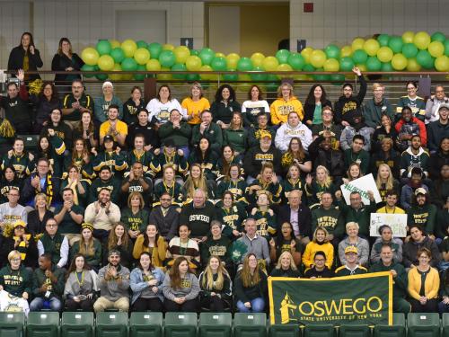 Group of students, faculty, staff and alumni in green and gold