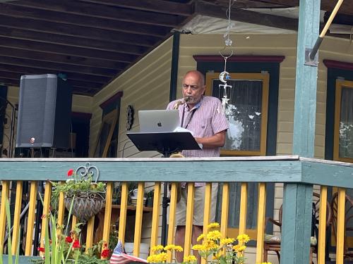 Shashi Kanbur plays the saxophone on a porch
