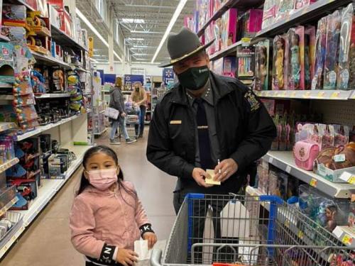 University Police Chief Kevin Velzy helps young shopper Karla find presents for her family during Shop With a Hero