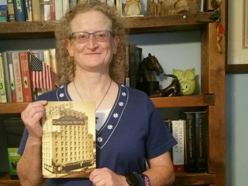 Political science faculty member Helen Knowles holds book on Cascadian Hotel