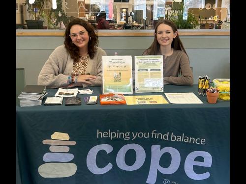 Patrycja Kulesza (right) and Madison Flood table for SUNY Oswego's Counseling Outreach Peer Educators