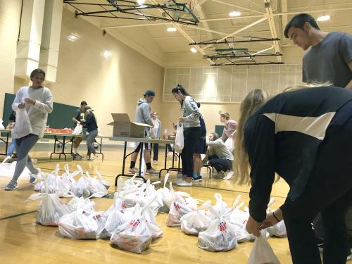 Laker student-athletes packing bags of food