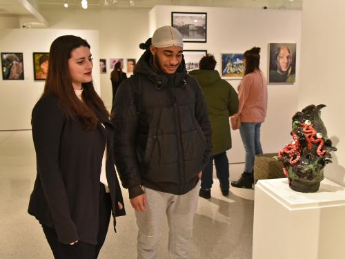 Shea McCarthy looks at her sculpture during Juried Student Exhibition