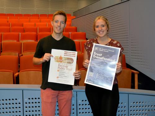 Josh Holfoth and Tori Kammer holding posters from the first media summit in 2005 and the 2019 edition