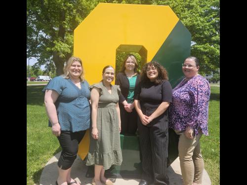 Members of the new Office of Student Wellbeing and Care gather around the Spirit O on campus