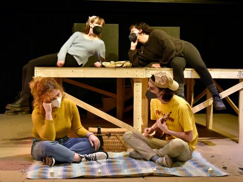 Four theatre students rehearse in two rows having two conversations