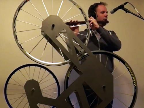 Music faculty member Paul Leary with instrument that combines flute with bicycle wheels