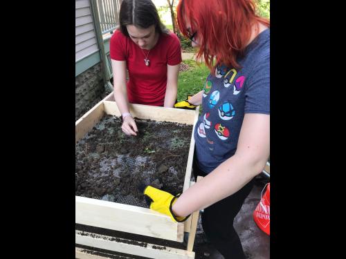 SUNY Oswego student archaeologists dig in while examining items they have unearthed at the local historic home and museum known as the Richardson-Bates House