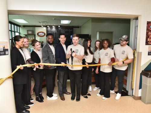 Students in SUNY Oswego’s Management 444 class hold a ribbon-cutting ceremony during an April 11 grand opening for the new Rich N’ Pour Cafe in the Rich Hall lobby.