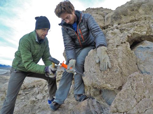 Faculty member Justin Stroup helps collect rock samples on a mountain