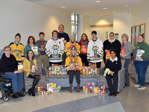 Laker hockey players with United Way and campus organizers collecting toy and food donations