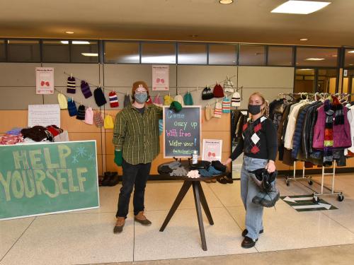 Sustainability Office students showing off coats, boots, hats, gloves and scarves available for free