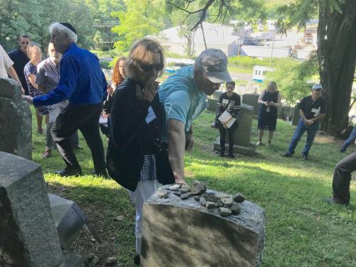 Former European refugees and families walk through a cemetery in Fort Ontario