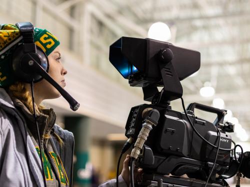 Tara O'Donovan operates a camera at an Oswego hockey game