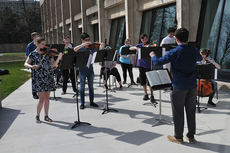 Lab orchestra practices outdoors