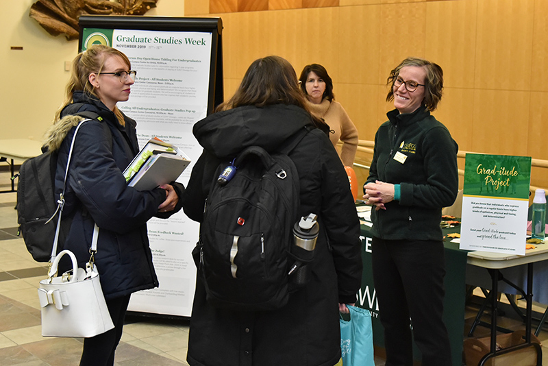 Laura Spenceley, assistant dean for graduate studies, staffs the Grad-itude event held Nov. 11, speaking with two graduate students in school psychology