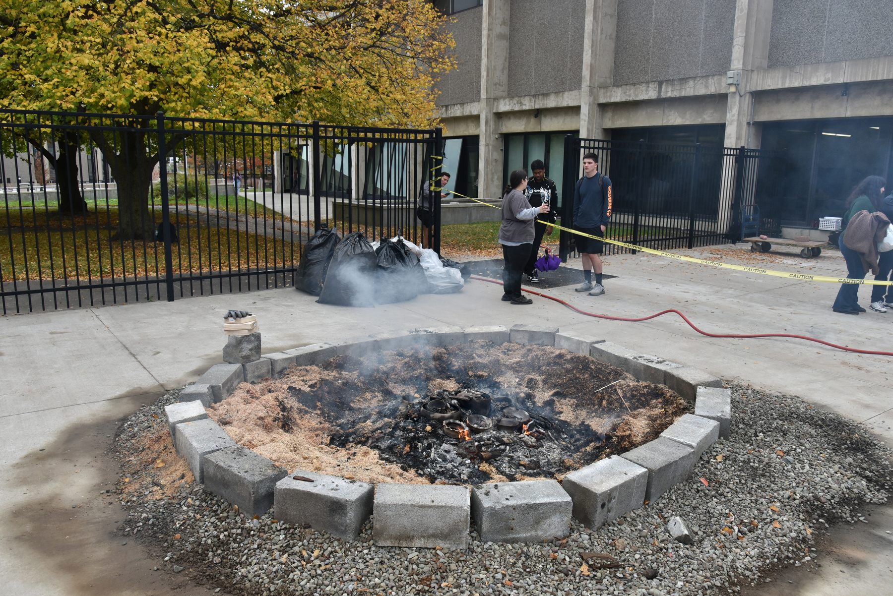 Art students working in ceramics used the pit-fire method of firing their clay sculptures, a practice that allows the introduction of additional ingredients into the clay and glazes to obtain certain effects. The ceramic firing was held Oct. 20 in conjunction with the annual Iron Pour outside Tyler Hall.