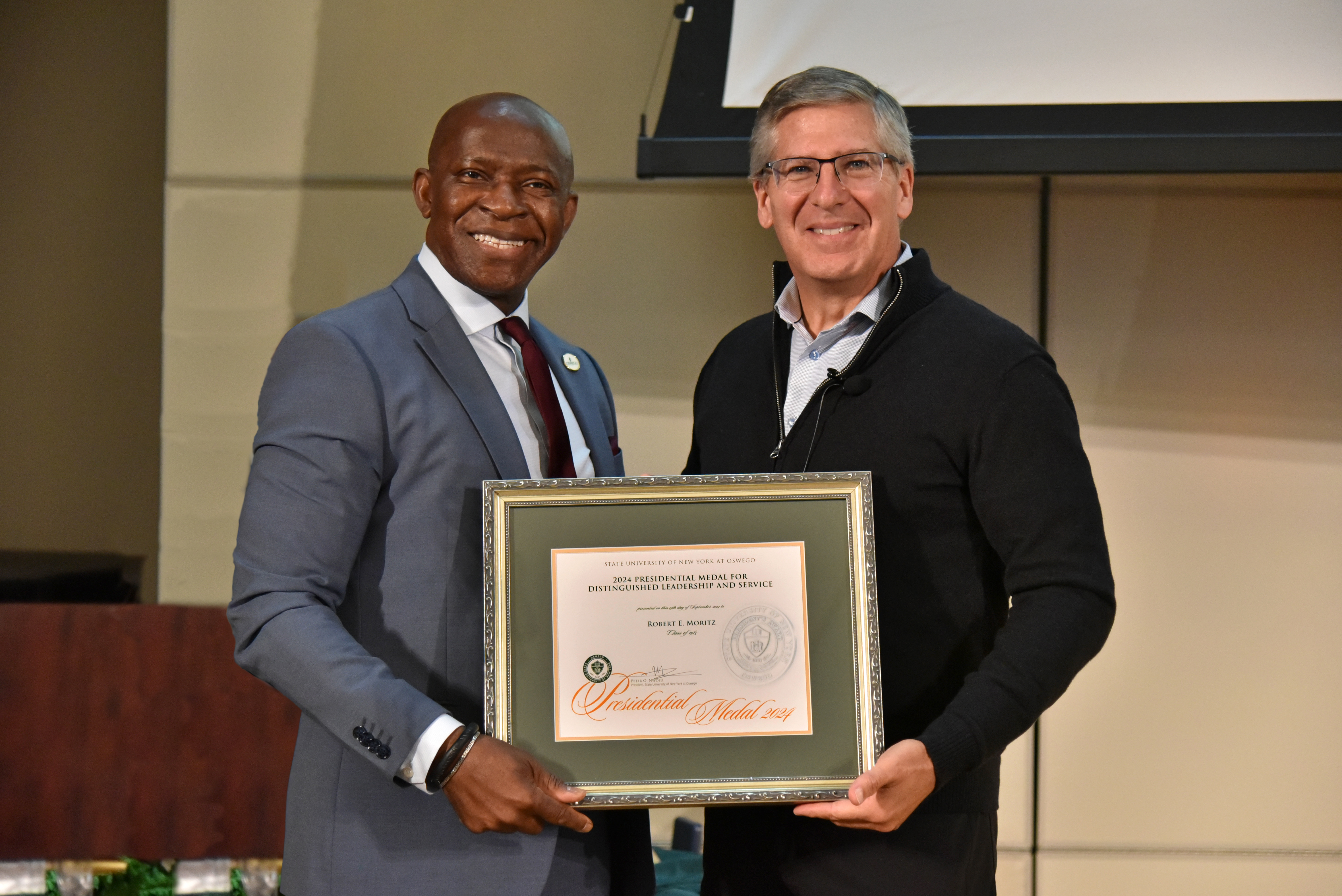 SUNY Oswego President Peter O. Nwosu on Sept. 25, presented 1985 alumnus Bob Moritz with the prestigious Presidential Medal during the inaugural Sheldon Lecture on the university’s main campus in Oswego. 