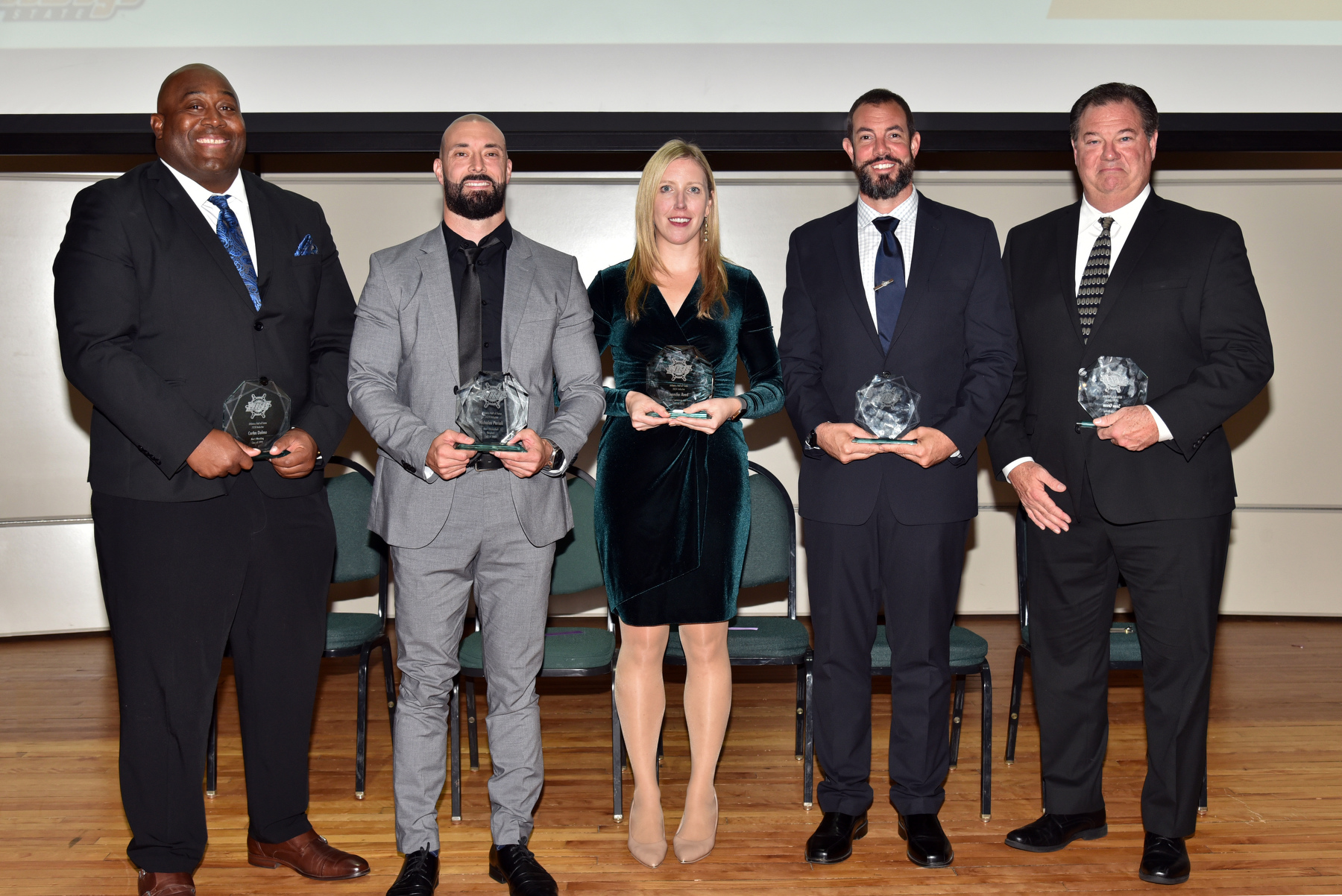 The SUNY Oswego Department of Intercollegiate Athletics inducted five Laker alumni into the 2024 Hall of Fame Class. Each inductee was honored during a dinner ceremony  held October 12 in Sheldon Hall ballroom. Inductees, from left, include: Carlos Dolmo ’99, wrestling; Nicholas Perioli ’08, men's basketball and baseball; Jennifer Reed ’10, women's swimming and diving; Gregory Doyle ’08, men’s swimming and diving; and Sean Green ’90, men’s hockey.