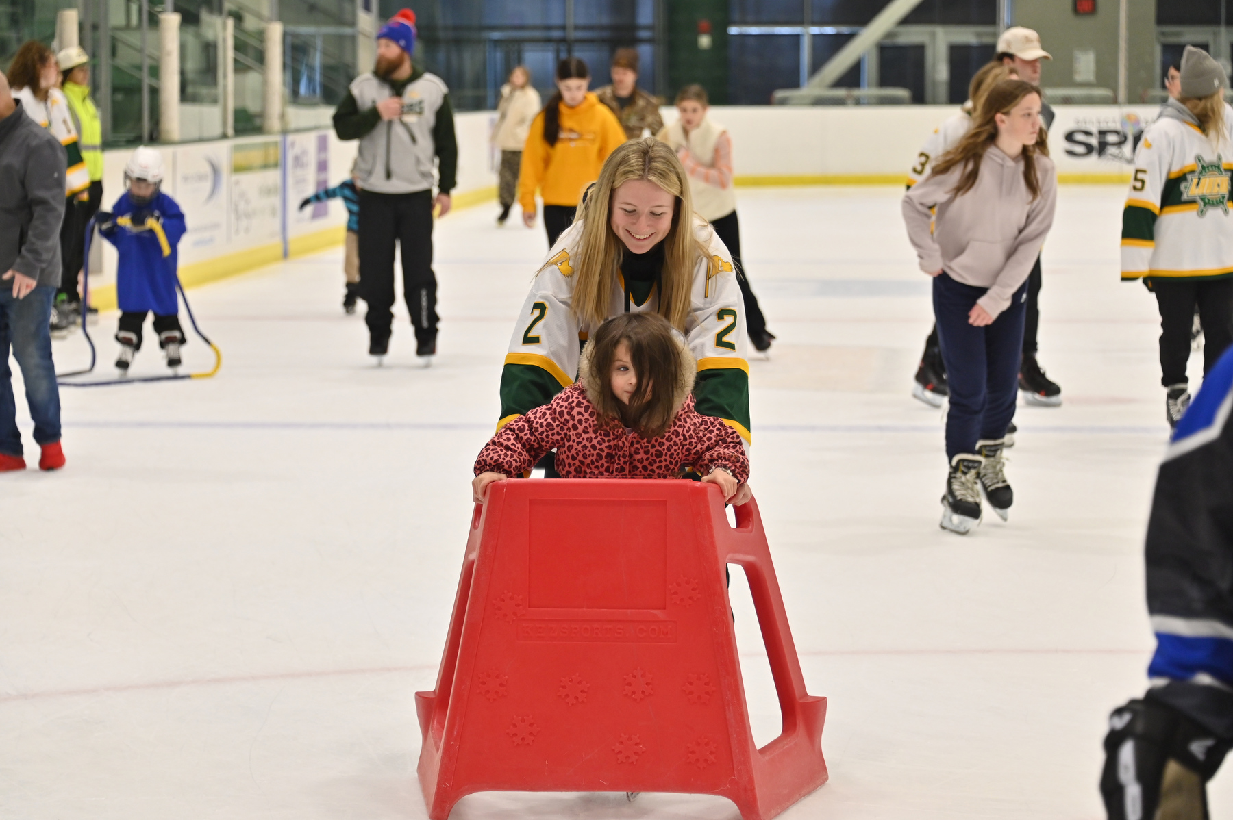 Mina Kraft, age 4, from Mexico, skates along with women's senior hockey team member Mack Hull (#2) at the Dec. 6 Holiday Skate with the Lakers in the Deborah F. Stanley Arena and Convocation Hall. The popular event welcomes skaters of all ages while raising funds for the United Way of Greater Oswego County.