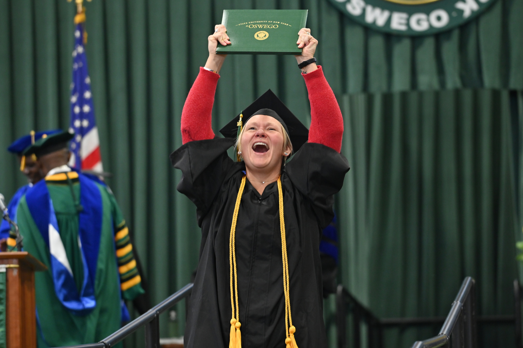 Brittany Pace, a cum laude graduate and a staff member in SUNY Oswego's Admissions Office, exudes joy at Commencement.