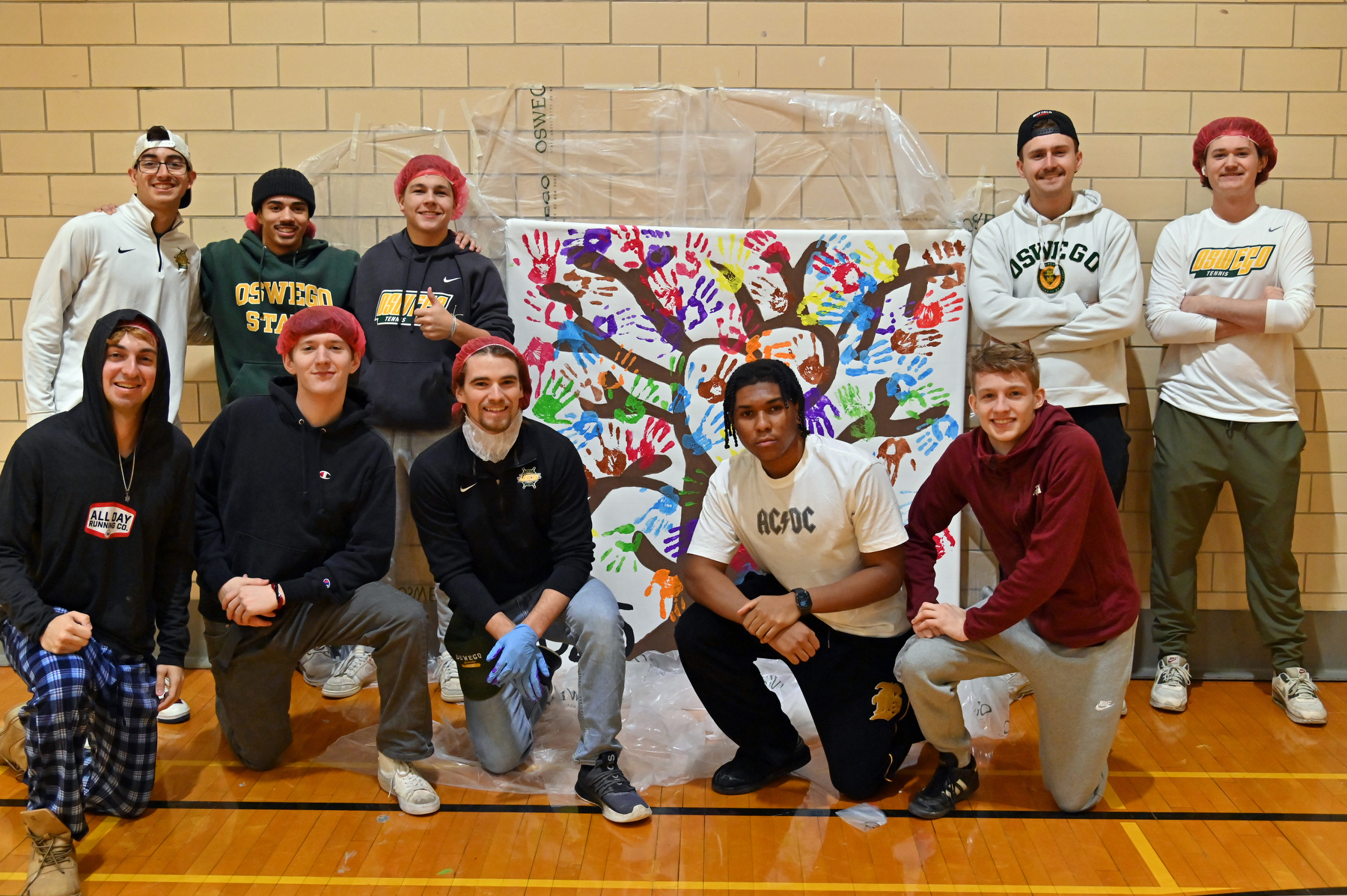 The Martin Luther King, Jr. Day of Service also included the 2025 SUNY Oswego Tree of Life painting. Students make their mark on the canvas with their handprints using a color with a value that is most important to them. Pictured is the men's tennis team participating. The theme for this year's events was “Communities in Action: Empowering The Dream.”