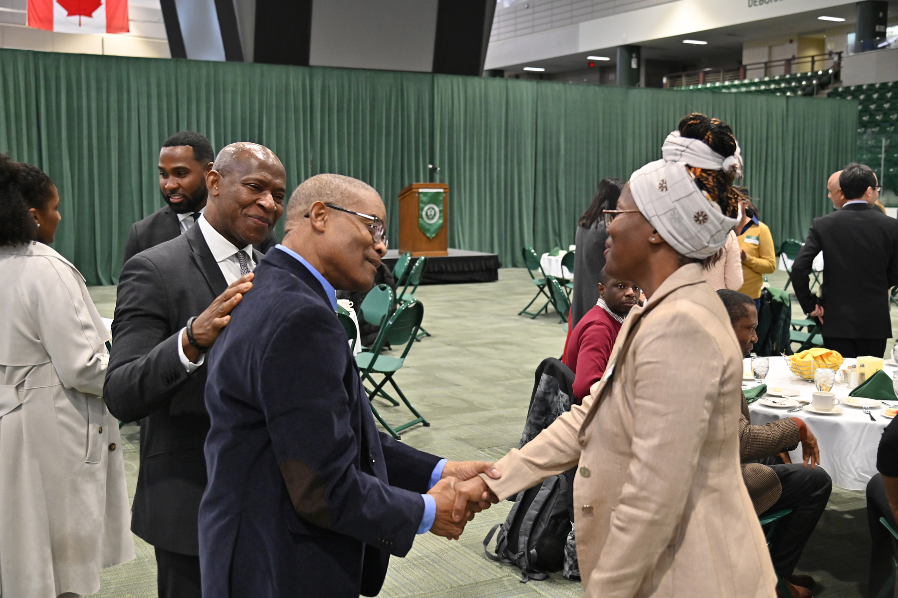 The annual Faculty and Staff of Color dinner was held March 27 in the Deborah F. Stanley Arena and Convocation Hall of Marano Campus Center. Pictured, Howard Gordon, a now-retired, long-serving and dedicated member of the college in the President's Office, and college President Peter O. Nwosu greet Barbara Streets, an associate professor of counseling and psychological services. President Nwosu provided the evening's keynote address.