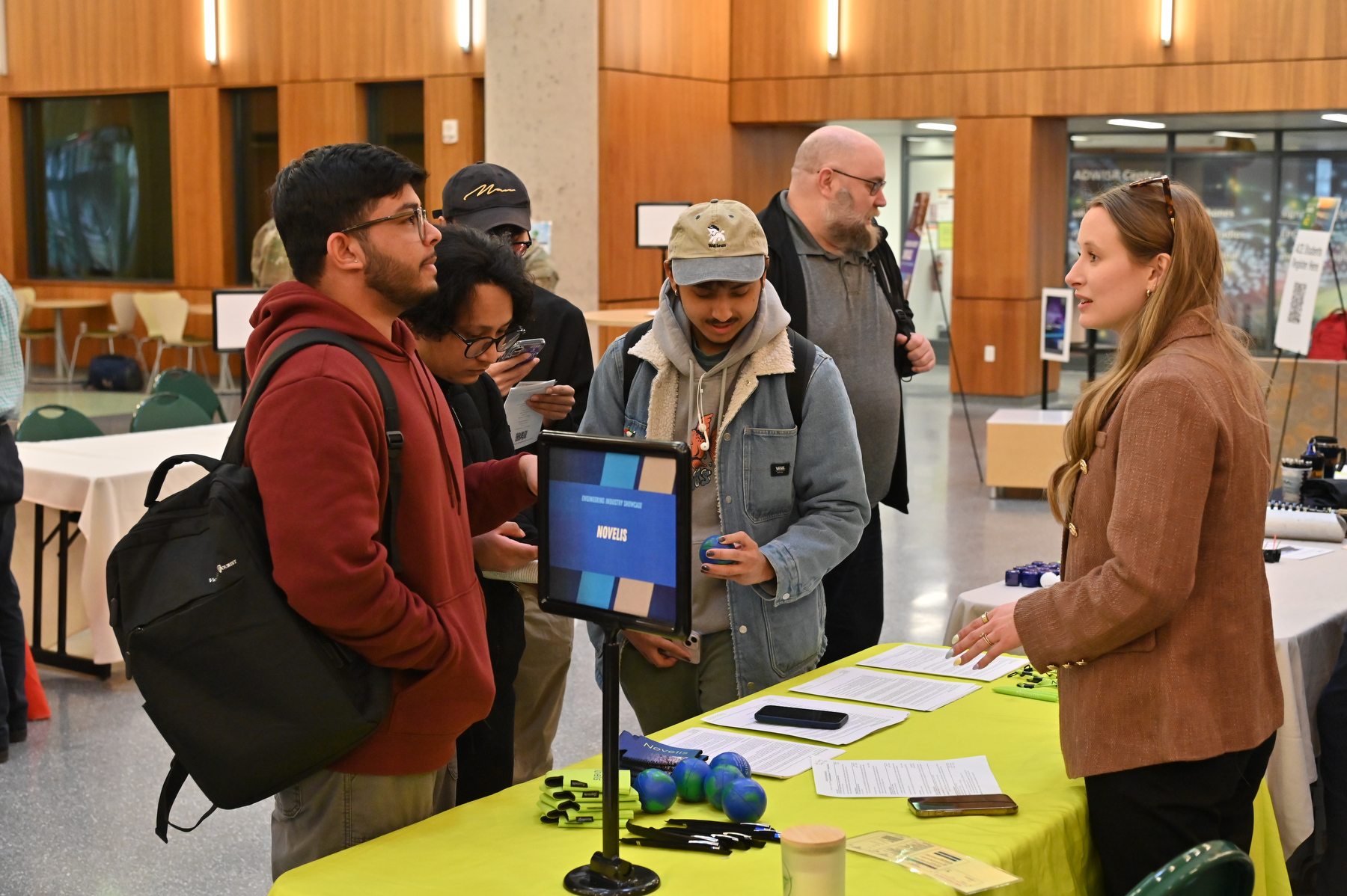 Representatives from local engineering industries, graduate programs and professional organizations met with current students in an Engineering Industry Showcase career fair to discuss the job opportunities at their organizations. Pictured, a group of students speak with a representative from Novelis at the April 2 event held in the Shineman Center Nucleus, part of Engineering Week events. 